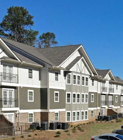 a row of apartment buildings with cars parked in front of them