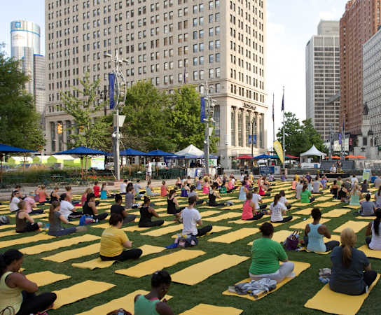 people sitting on blankets in a park in a city