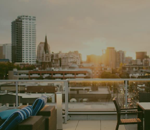 a view of the city skyline from a rooftop terrace with a table and chairs