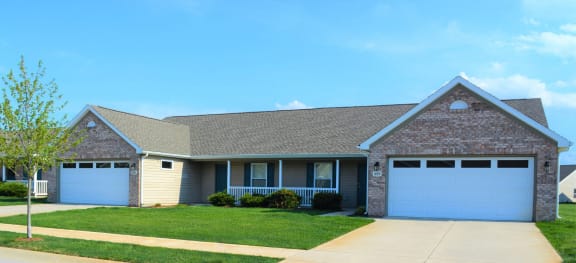 a house with two garage doors and a lawn  at Hawthorne Properties in Lafayette, IN 47905