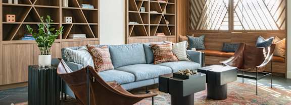 A living room with a grey couch, a brown chair, and a coffee table.