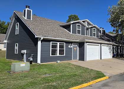 A two-story house with a garage and a driveway.
