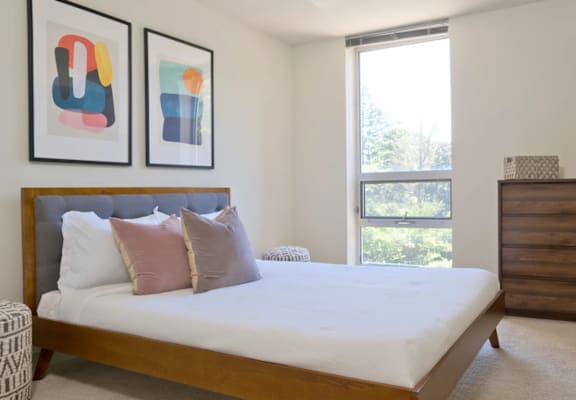 A bedroom with a large bed and a chair.
