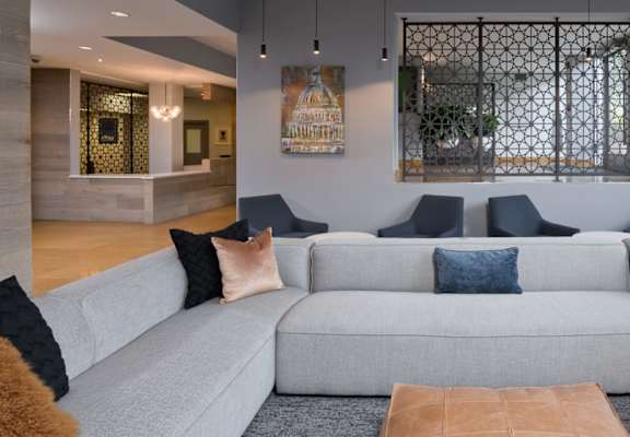 A grey couch with blue and brown pillows in a room.