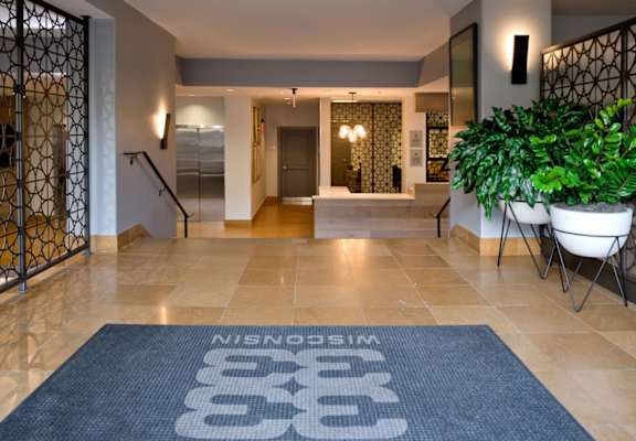 A hallway with a blue rug on the floor that says "Nestlé" on it.