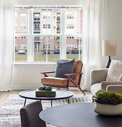 a living room with white walls and a large window