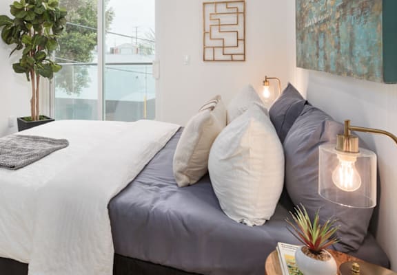 a bedroom with white walls and a large window