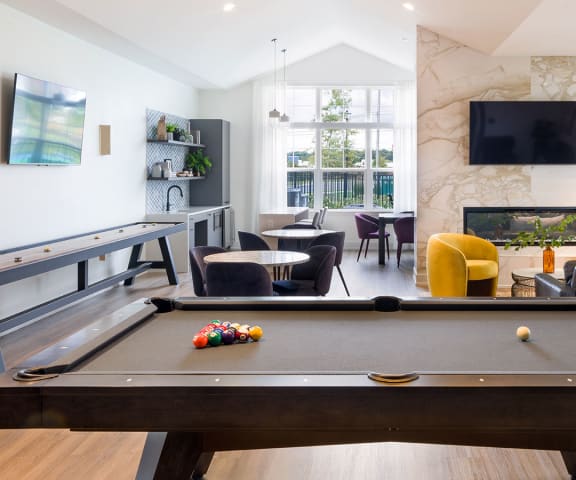 a living room with a pool table and a tv on the wall