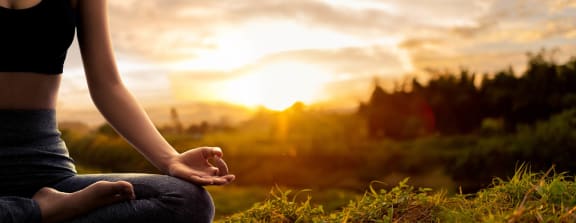 a woman meditates in a field at sunset at Rivulet, Silverdale Washington