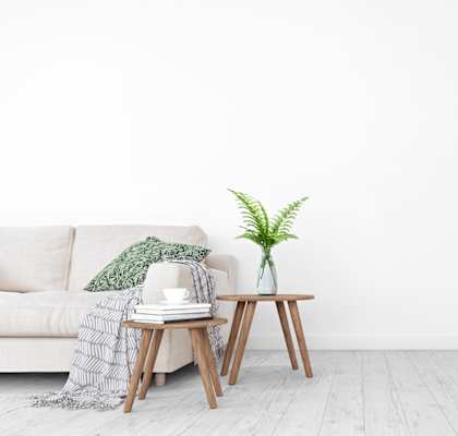 a white wall in a living room with a couch and a side table
