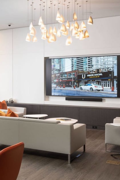 an apartment lobby with couches, a tv,  and a table and chairs