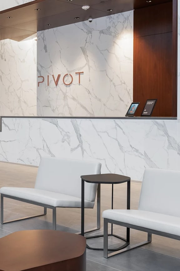 the lobby Pivot apartments with a white couch and chairs