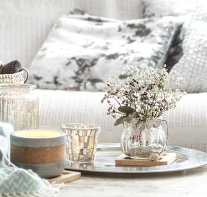a living room with a white couch and a coffee table with a tray with a vase