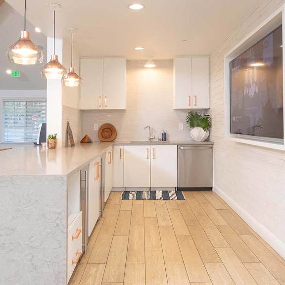 A modern kitchen with white cabinets and a wooden floor at Bella Vista at Hilltop Apartments, Richmond, CA, 94806