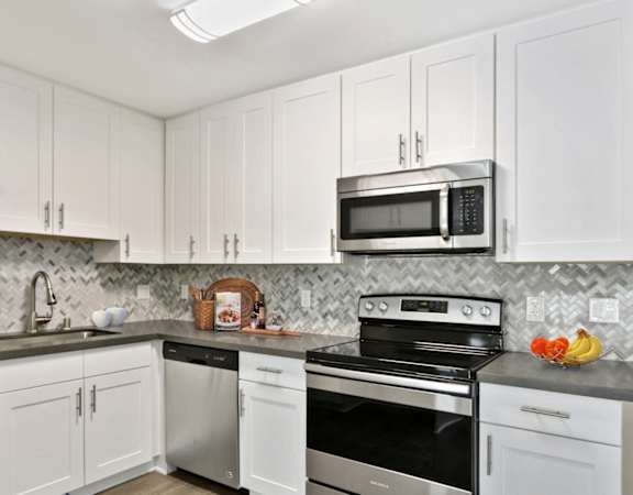 a kitchen with white cabinets and stainless steel appliances