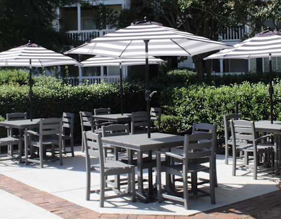 picnic tables with shady umbrellas surrounded by lush landscaping