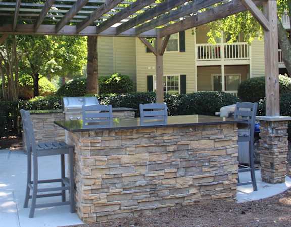 Grilling and dining area under a large pergola at Stillwater at Grandview Cove