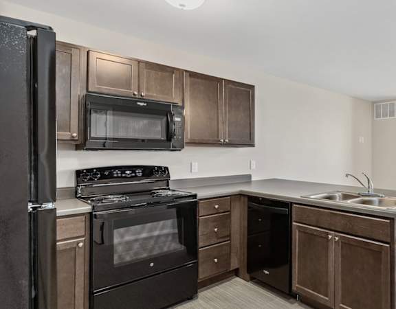 a kitchen with black appliances and wooden cabinets