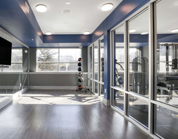 a workout room with a large window and a tv