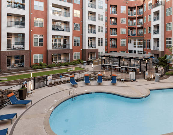 a swimming pool with an apartment building in the background