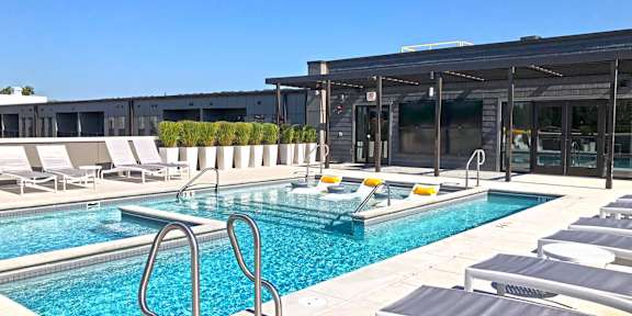 A pool with a diving board and sun loungers. at 1400 Russell Apartments, Saint Louis, 63104