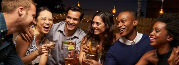 Friends Smiling while Having Drinks Together