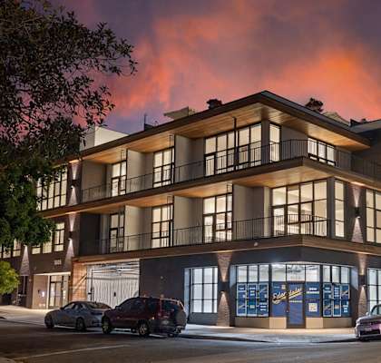 A modern building with a parking lot in front of it.