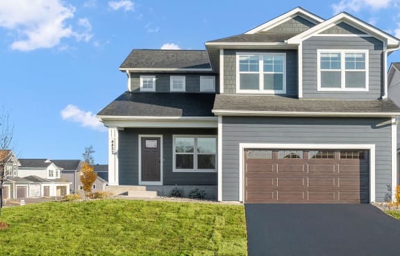 a house with a vinyl siding and a concrete driveway