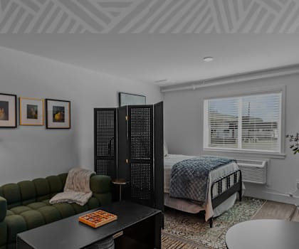 a bedroom with a bed and a couch and a table