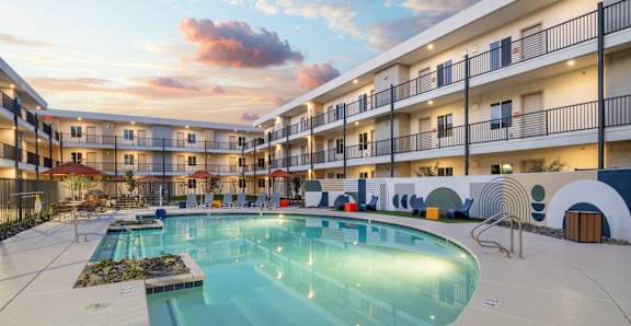 A swimming pool in front of apartment buildings.