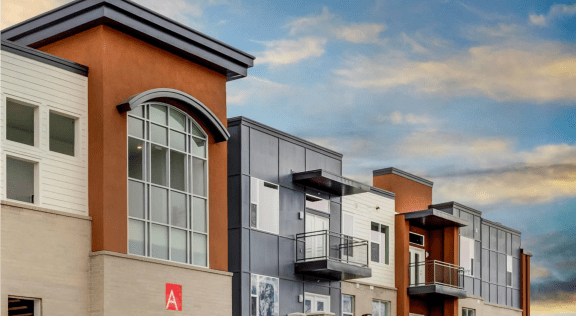 a rendering of a row of apartment buildings with a blue sky in the background