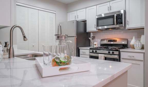 kitchen with stainless appliances and white cabinetry at The Residence at Christopher Wren apartments