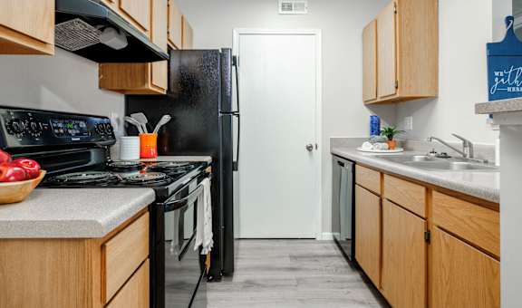 a kitchen with wooden cabinets and a black stove and refrigerator