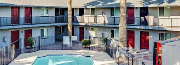 A balcony of a building with a pool in the foreground.