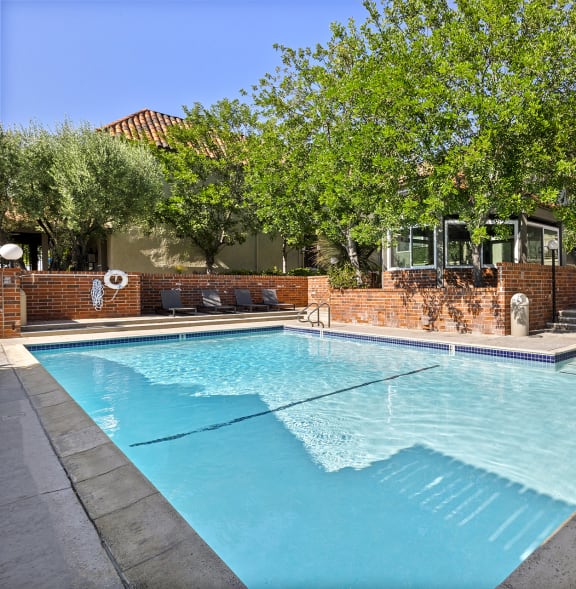 a patio with tables and umbrellas outside of a house