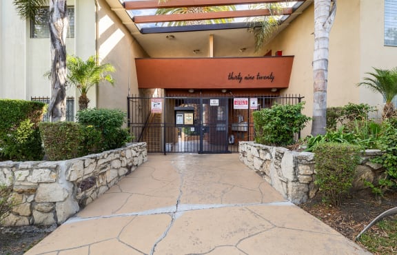 the entrance to a building with a stone walkway and a gate
