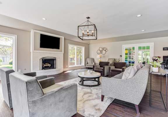 A modern living room with a grey sofa and a fireplace.