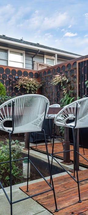 a small patio with two chairs and a table on a wooden deck