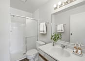 Thumbnail 23 of 24 - A white bathroom with a toilet, sink, and mirror.