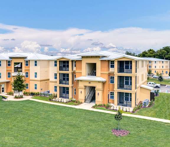 an aerial view of an apartment complex with a green lawn