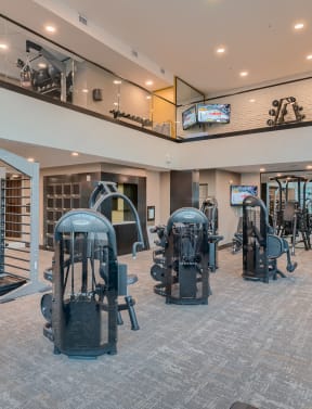 a spacious fitness room with cardio equipment and weights