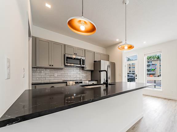 A modern kitchen with a black countertop and stainless steel appliances at Westwood Meadows, Westlake, OH, 44145