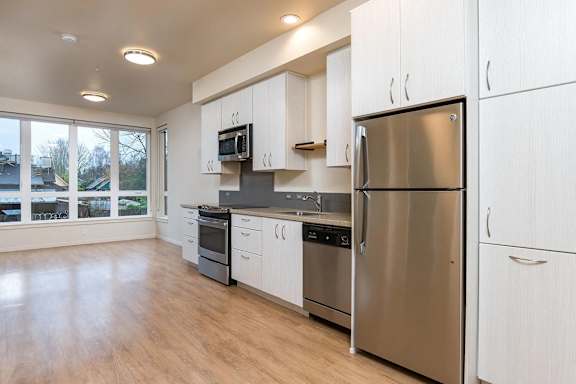A modern kitchen with stainless steel appliances and white cabinets.