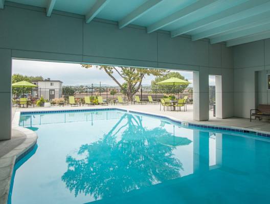 A swimming pool in a building with a glass wall. at Park 88 Apartments, Thornton, CO, 80229