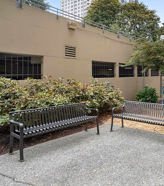 two park benches in front of an apartment building
