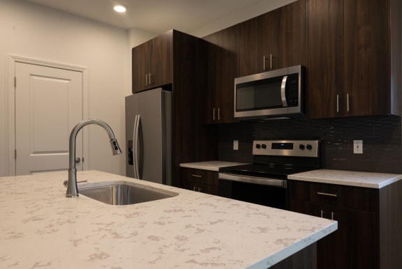 a kitchen with stainless steel appliances and quartz countertops at The Clearing at ONE28, Olathe, KS, 66062