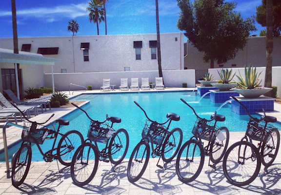 A row of bicycles are parked by a pool.at Winfield of Scottsdale, Scottsdale