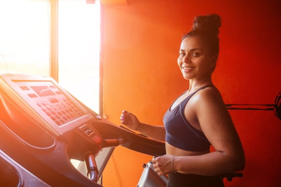 This ia a photo of a woman running on a treadmill.