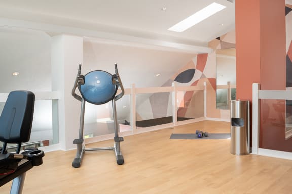 a workout room with a blue exercise ball and a treadmill