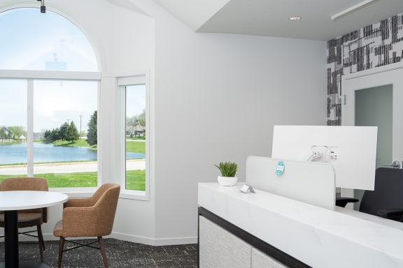 a living room with a view of a lake and a table and chairs
